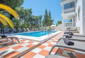 a swimming pool in a villa with chairs around it at Villa Domus Vesta in Marbella