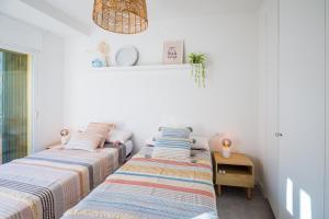 two beds in a room with white walls at La Calma in Platja d'Aro +25 photos