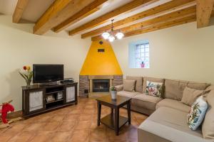 a living room with a couch and a tv at Casa Lindelagua in Pámanes