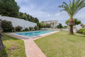 a swimming pool in a yard with a palm tree at Mi Casa in Caleta De Velez +17 photos
