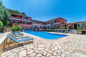 a swimming pool with lounge chairs in front of a building at Arianna Studio 15 in Paleokastritsa