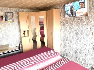 a small room with a bed and a tv on the wall at Ferienwohnung Beyer Friedrichroda in Friedrichroda