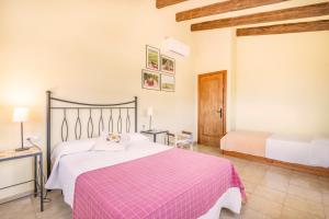 a bedroom with a bed with a pink blanket at Cal Maso in Hostafranco