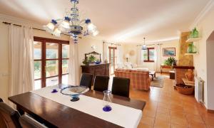 a dining room with a table and a living room at Casa Tolo in Son Servera