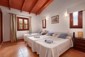 a bedroom with two beds and a couch at Casa Tolo in Son Servera +15 photos