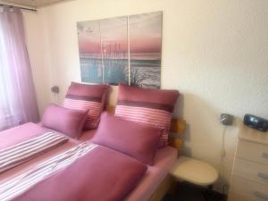 a bed with pink pillows on it in a room at Ferienwohnung Beyer Friedrichroda in Friedrichroda +37 photos