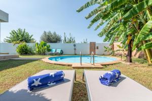 a pool with two blue pillows on a table in a yard at Villa Zoe in Palma de Mallorca