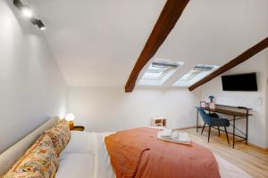 a bedroom with a bed and a desk with a television at La Scaletta in Biella
