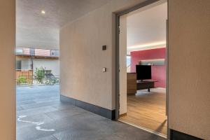 an open door to a living room with a television at Aumia Apartment Rubin in Völs am Schlern