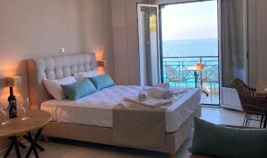a bedroom with a bed with a view of the ocean at Sunset Premium Studio D in Lefkada +22 photos