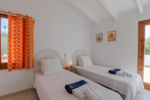 two twin beds in a room with a window at Villa Diani in Binibeca +31 photos