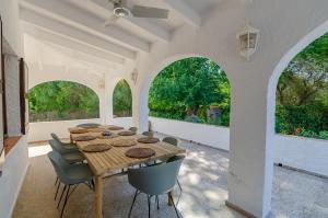 a dining room with a table and chairs and windows at Villa Diani in Binibeca