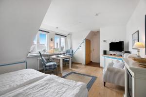 a bedroom with a bed and a desk with a television at Ferienwohnung Haus Lazy Dolphin in Rantum