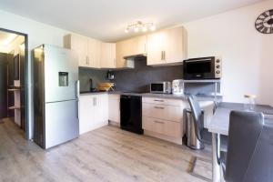 a kitchen with white appliances and a table with chairs at Appartement Albiez in Albiez-Montrond