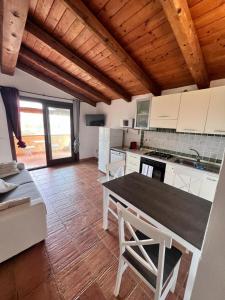 a kitchen with white cabinets and a table and chairs at Orizzonti 32 in Golfo Aranci