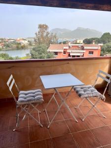 a white table and two chairs on a balcony at Orizzonti 32 in Golfo Aranci +4 photos