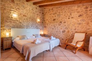a bedroom with two beds and a chair at Son Xigala in Manacor +19 photos