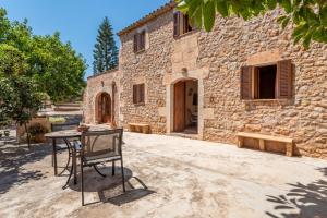 a table and chair in front of a stone building at Son Xigala in Manacor