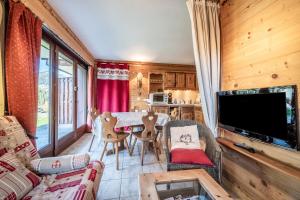 a living room with a table and chairs and a television at Appartement T3 Chatel in Châtel