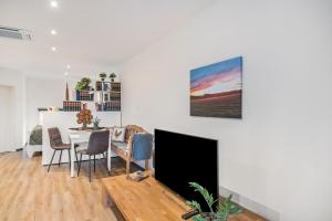 a living room with a television and a table with chairs at Ferienwohnung Eifelzauber in Greimerath