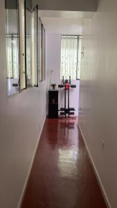 a hallway with white walls and a table and windows at Minidepartamento en Huaral in Huaral