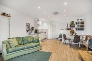 a living room with a green couch and a kitchen at Ferienwohnung Eifelzauber in Greimerath