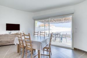 a dining room with a table and chairs and a television at Le Boumian in Saintes-Maries-de-la-Mer