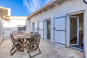 a patio with a table and chairs in front of a building at Le Boumian in Saintes-Maries-de-la-Mer