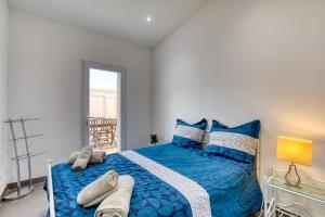 a bedroom with a blue bed with towels on it at Le Boumian in Saintes-Maries-de-la-Mer