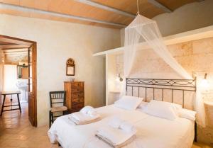 a bedroom with a large white bed with white pillows at Son Reus in Felanitx