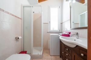 a bathroom with a toilet and a sink and a shower at Casa Vacanza Ghisu in SantʼAnna Arresi +15 photos
