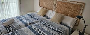 a bedroom with a bed with a blue and white quilt at Ainara Luxury in Lloret de Mar +36 photos
