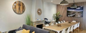 a dining room with a table and a clock on the wall at Ainara Luxury in Lloret de Mar