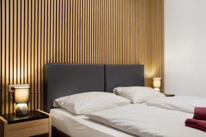 a bedroom with two beds and a wooden wall at Maiglöckchen in Unterwittighausen