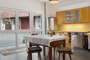 a kitchen with a table and chairs and a kitchen with windows at Maiglöckchen in Unterwittighausen