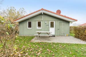 a green shed with a picnic table in front of it at Skipper-Lodge West in Kosel