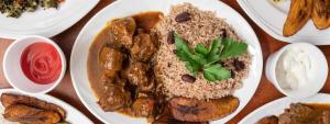 a plate of food with rice and meat and other foods at EBENEZER Cottage in Discovery Bay