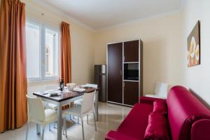a living room with a red couch and a table at Palazzo Mongiò in Gallipoli
