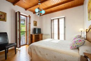 a bedroom with a bed and a chair and a television at Aldea Salguero in Albandi