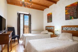 a hotel room with two beds and a television at Aldea Salguero in Albandi