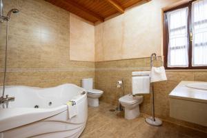 a bathroom with a tub and a toilet and a sink at Aldea Salguero in Albandi +24 photos
