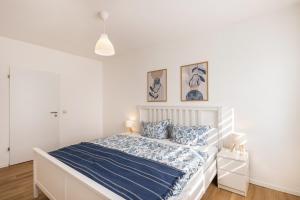 a bedroom with a white bed with blue sheets at Ferienwohnung Mücheln in Mücheln