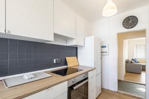 a kitchen with white cabinets and a clock on the wall at Ferienwohnung Mücheln in Mücheln