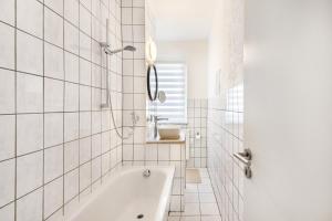 a white bathroom with a tub and a sink at Ferienwohnung Mücheln in Mücheln +15 photos