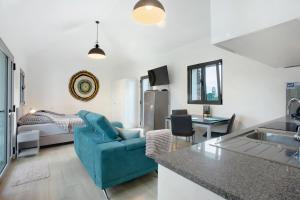 a living room with a blue couch and a kitchen at Casa Do Vinho in Porto Santo