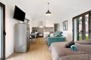 a room with two beds and a living room and a kitchen at Casa Do Vinho in Porto Santo +16 photos
