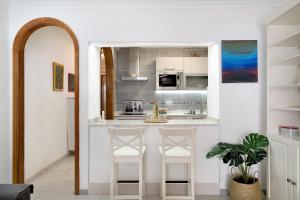 a kitchen with two white bar stools in a room at Casa Carmen in Puerto del Carmen