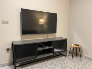 a black entertainment center with a flat screen tv on a wall at Dimora Vibo Centro in Vibo Valentia