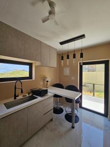 a kitchen with a sink and a table with chairs at Happy stay297 in Paradera