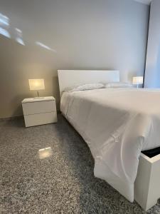 a bedroom with a white bed with a lamp on it at Dimora Vibo Centro in Vibo Valentia